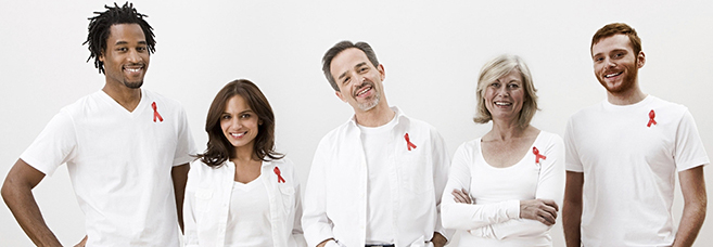 Grupo de personas con listones rojos. © Image Source Photography/Veer